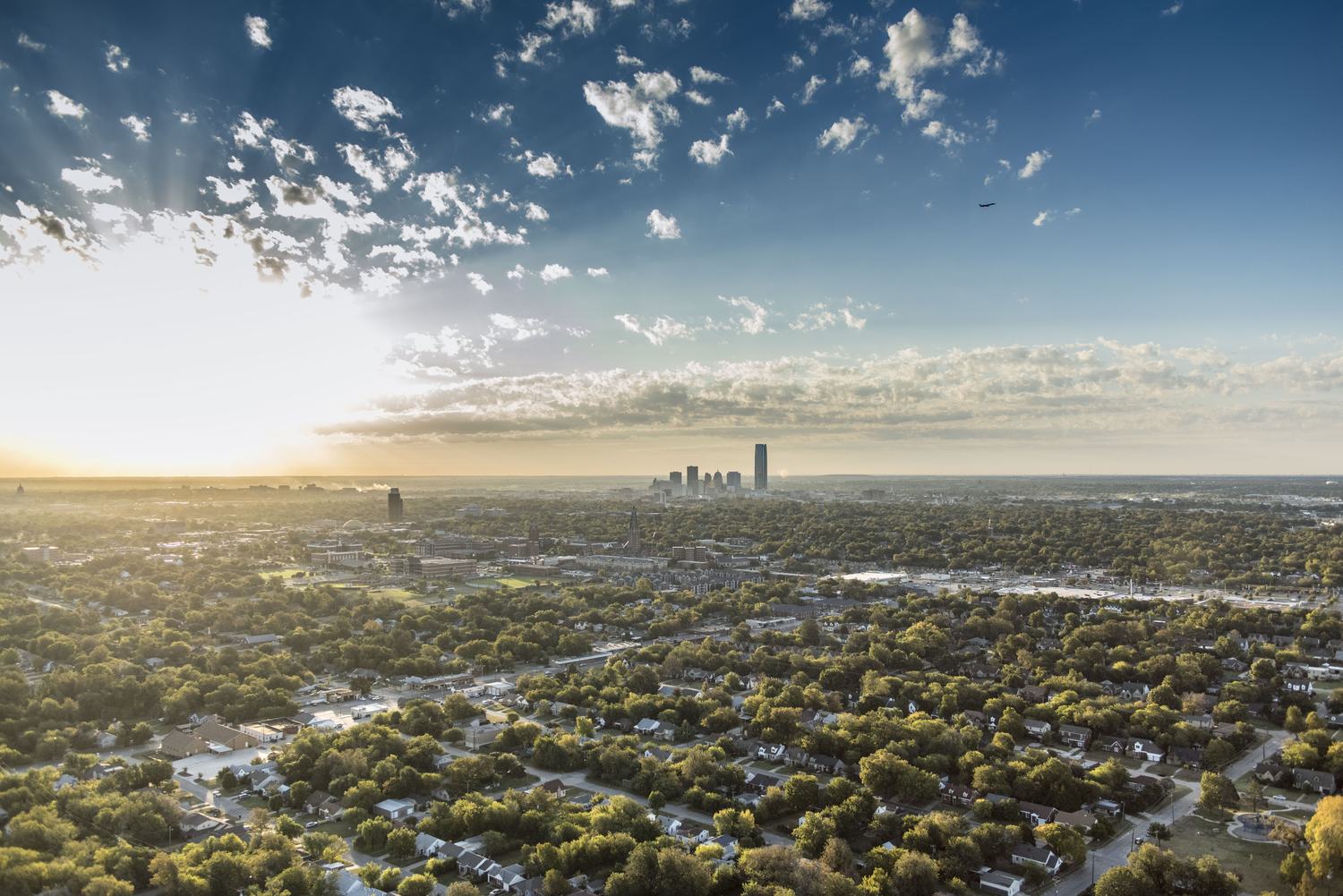 Sunset over Oklahoma City neighborhoods with skyline on the horizon